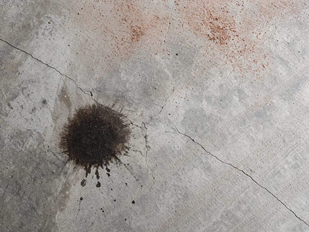 Example garage slab with cracks and oil before coating. Educational sample.